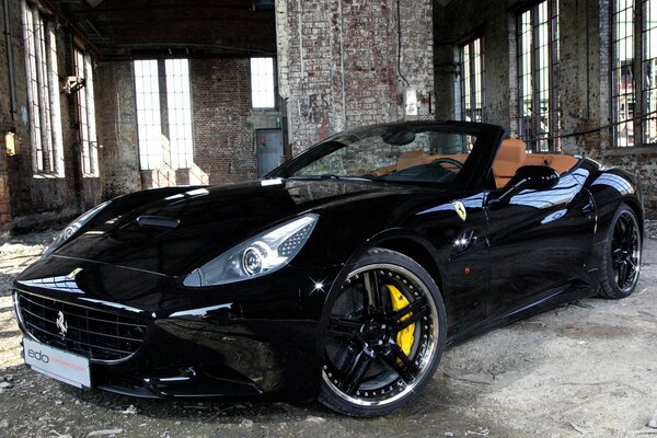 A black Ferrari with brown solon in an abandoned building