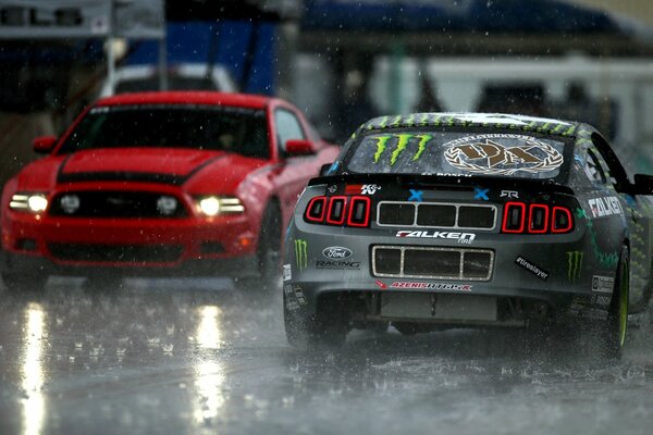 Two tuned sports cars on a wet track