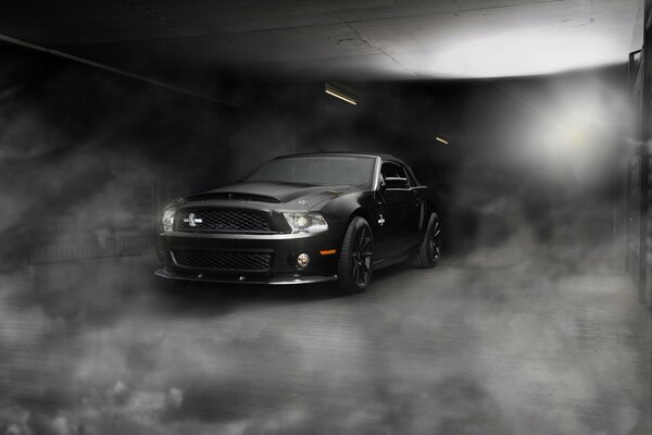 In the haze, the Ford Mustang is black