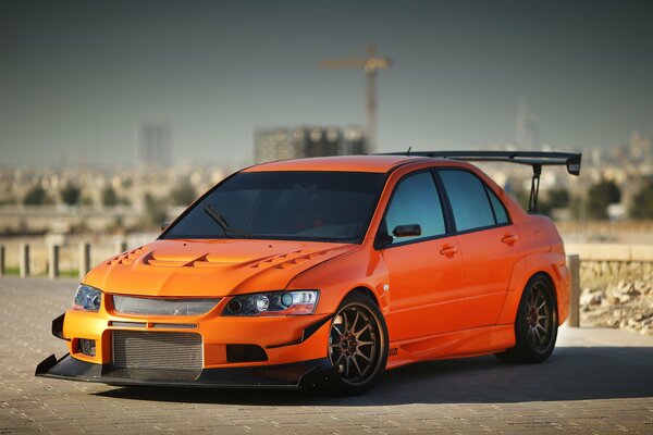 Orange Mitsubishi lancer auf Stadt Hintergrund