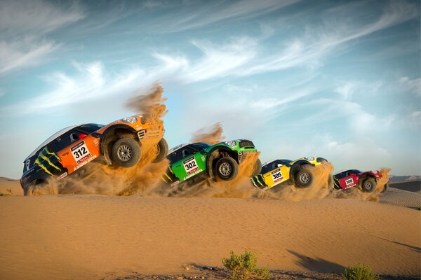 Mini coopers at the start rearing up in the desert