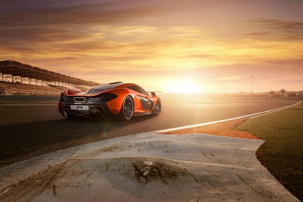 McLaren rojo y negro en el fondo de la puesta de sol