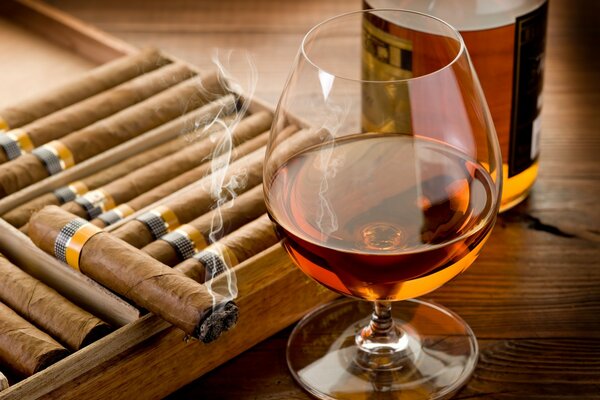 Un verre de cognac et un cigare allumé