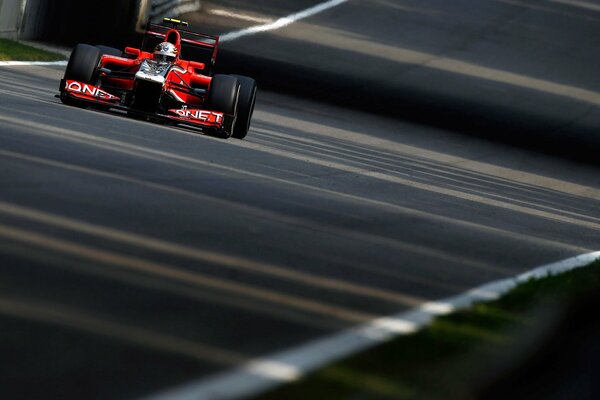 A red sports car is driving on the road