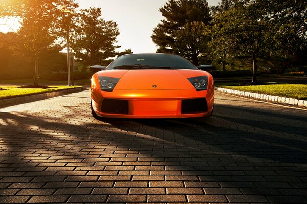 Lamborghini Orange auf Pflastersteinen im Schatten