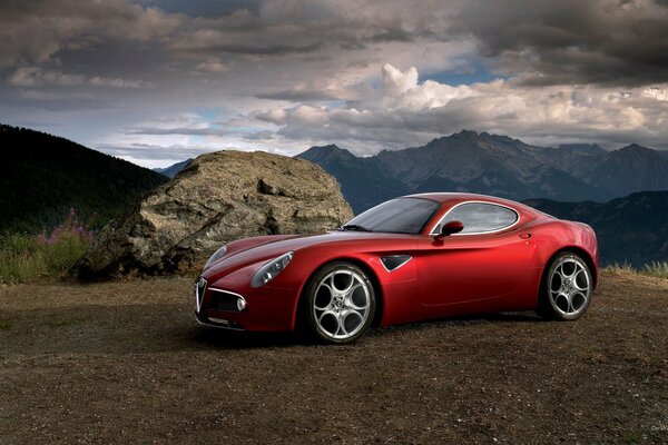 Rotes Alfa Romeo vor dem Hintergrund einer Berglandschaft