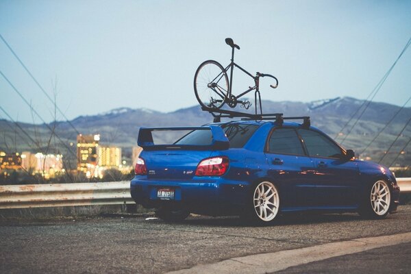 Subaru impreza wrx se para en la carretera con una bicicleta en la azotea