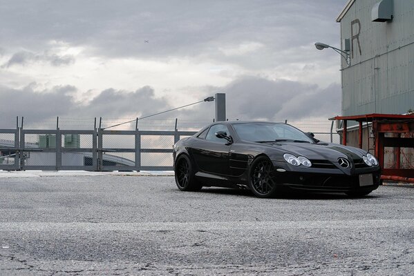 Black Mercedes at the gate with barbed wire