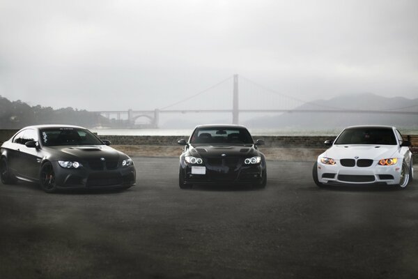 Three BMWs are parked next to each other