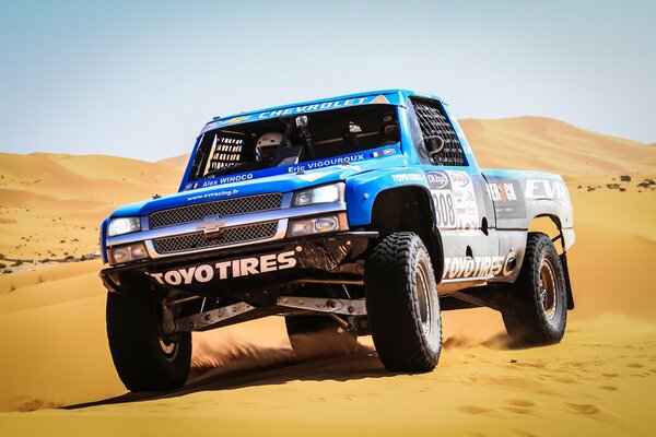 Coche de carreras en competencia en el desierto de arena