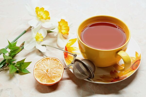 Thé au citron dans une belle tasse jaune et sur une soucoupe