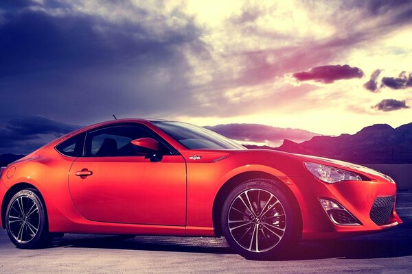 Sur fond de ciel orageux - voiture de sport rouge Subaru