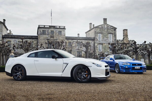 Nissan bianco e blu sullo sfondo di una bella casa con alberi