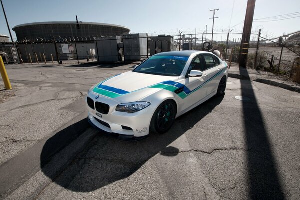 White BMW on asphalt with cracks. Side view