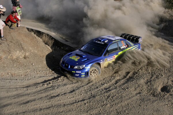 La subaru Impreza bleue entre dans un virage en course