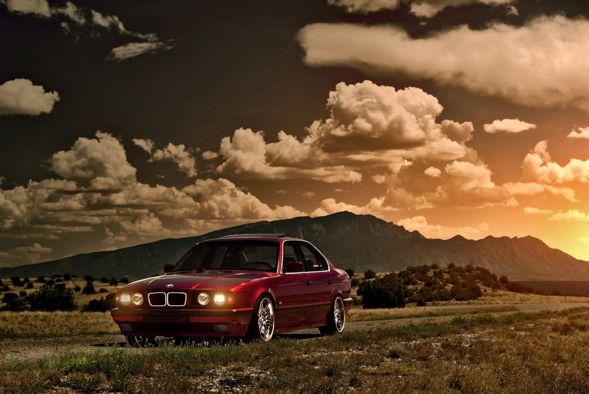 bmw serie 5 e34 rosso anteriore bmw rosso sole tramonto abbagliamento cielo nuvole montagne