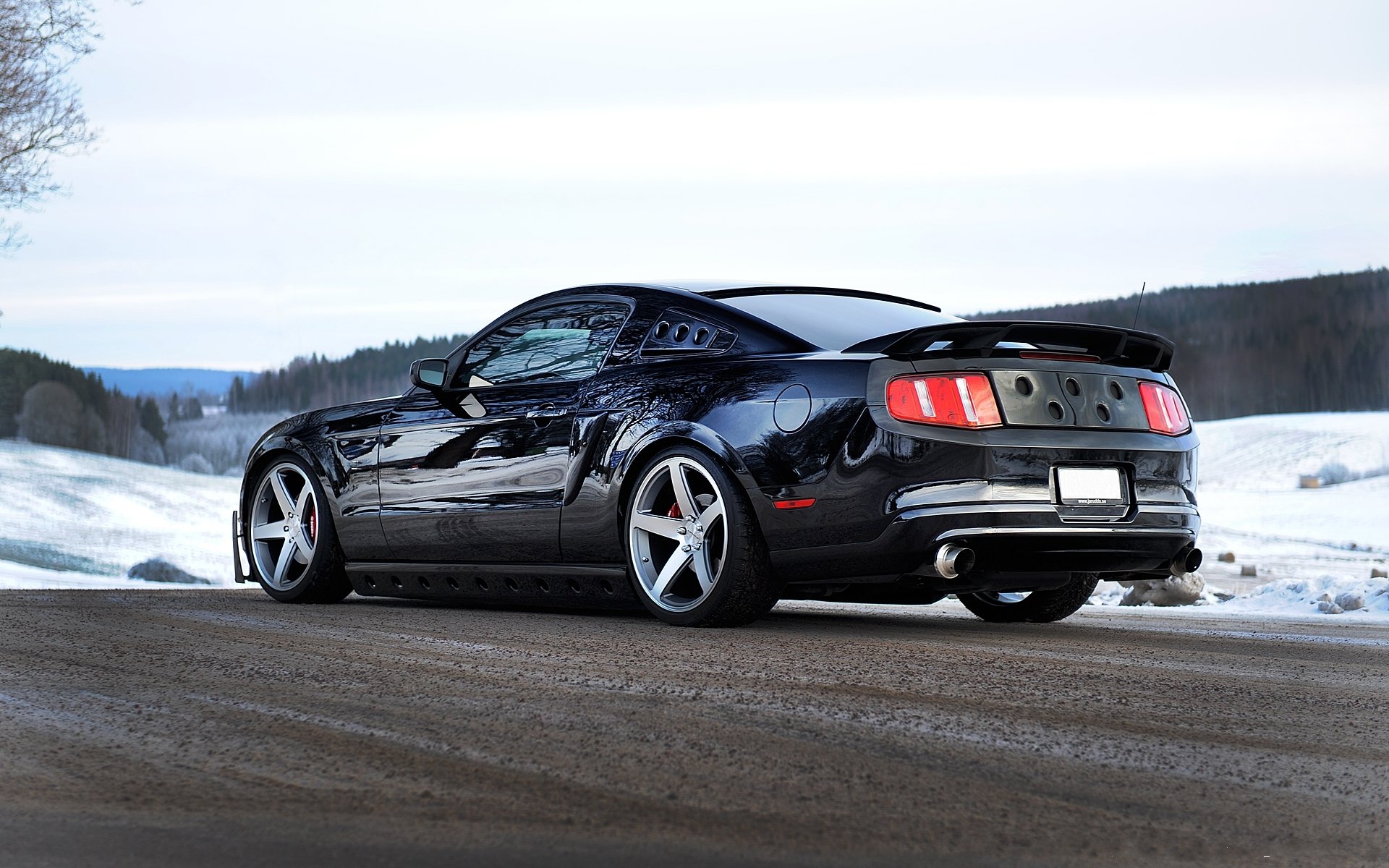 ford mustang black back of exhaust pipes road snow