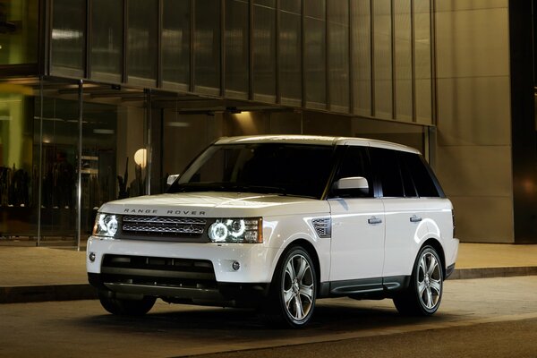 Ranger blanc Rover dans les rues de la ville de nuit