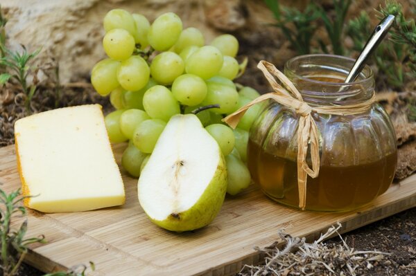 Tapete Obst Käse Honig auf Holzbrett