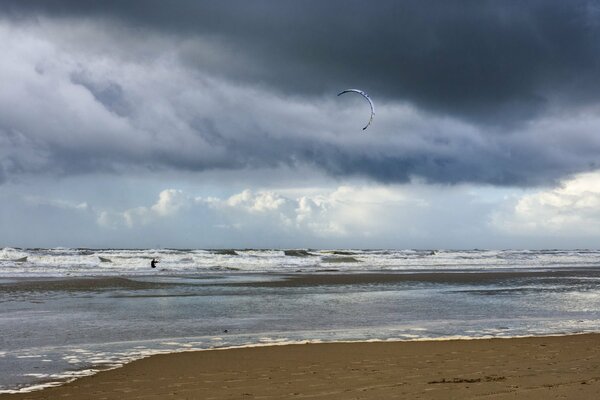 Niedriger Himmel mit düsteren Wolken am Meer mit Wellen