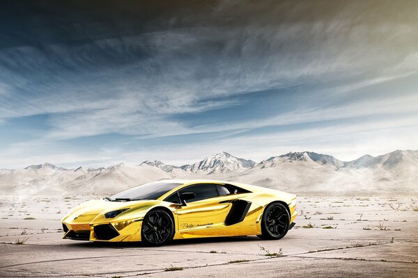 Lamborghini de cromo dorado sobre el fondo de las montañas