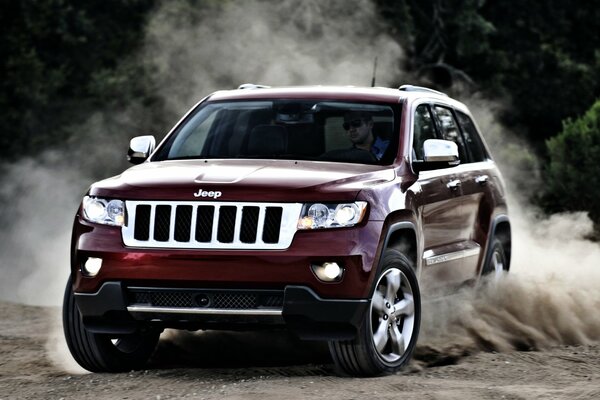 Jeep Cherokee rossa alla deriva/gira sulla sabbia