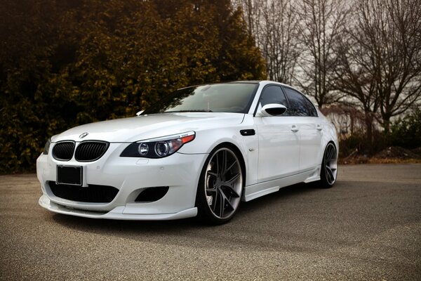 Blanco BMW sedán Tuning en la carretera