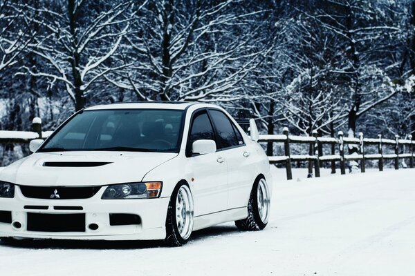 White Mitsubishi lancer in the snow in winter