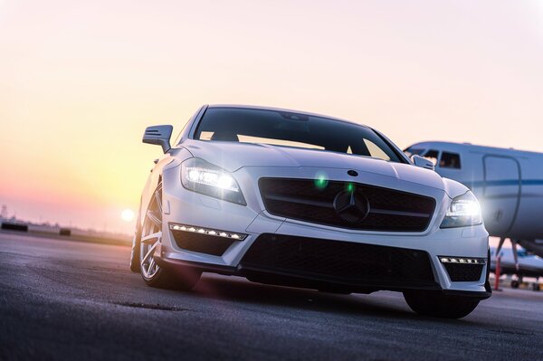 Mercedes at the airport and behind the plane and sunset