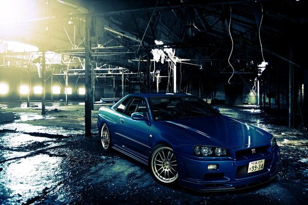 Blue Nissan skyline illuminated by floodlights