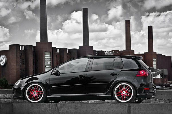 A black car on the background of the Volkswagen plant