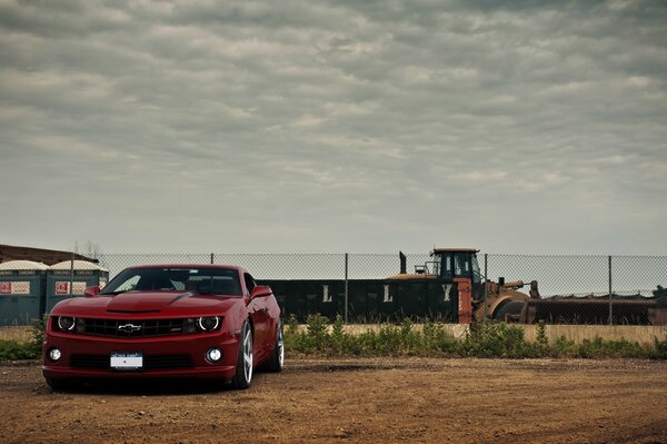 Chevrolet camaro on the background of a bulldozer. Front view