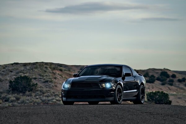 Schwarzer Ford Mustang auf einem düsteren Hintergrund