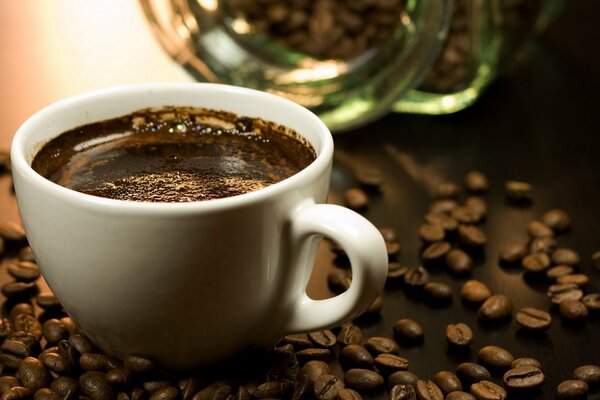 A cup of coffee among coffee beans