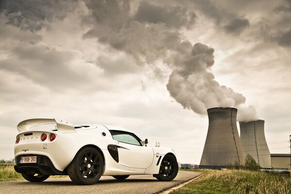 Sports car on the background of the smoking pipes of the station