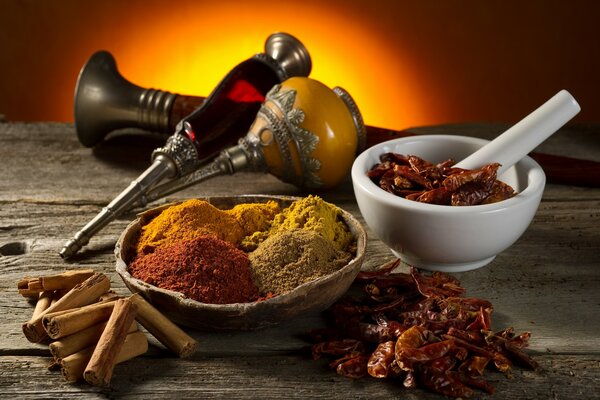 Spices in a mortar on the table such as red pepper, curry, cinnamon