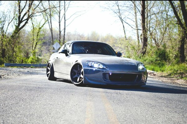 Honda s2000 en la carretera cerca del bosque