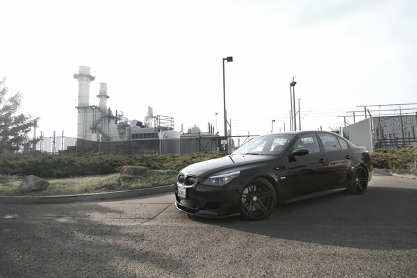 Schwarzer BMW auf dem Hintergrund der alten Fabrik