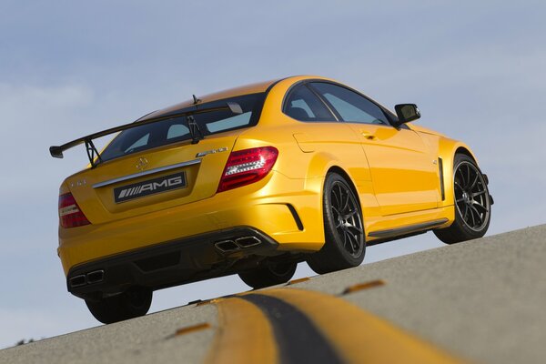 El mercedes-benz AMG amarillo rompe el doble sólido en la pista