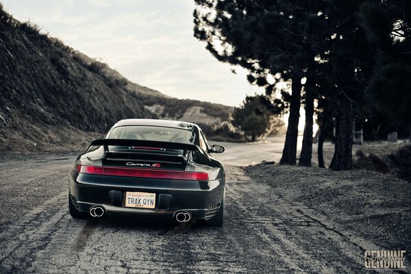 A beautiful black car is driving along the road