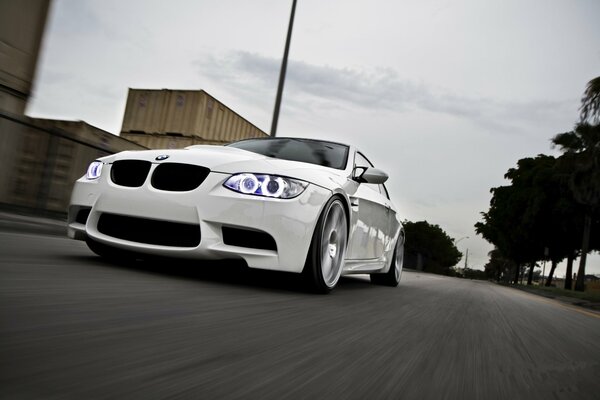 BMW blanco conduce por la carretera de la ciudad