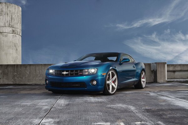 Chevrolet camaro blu nel parcheggio sotto le nuvole