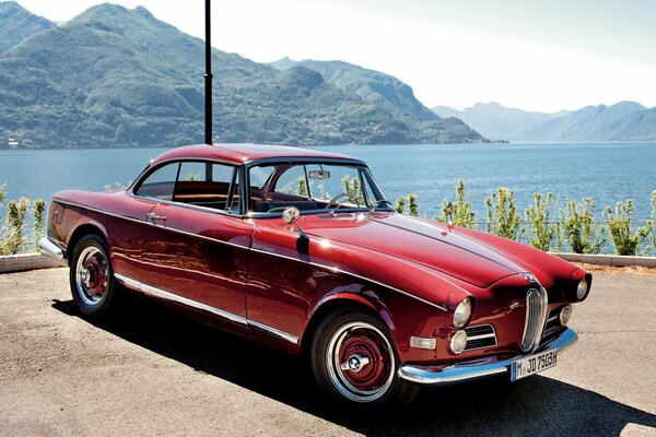 Rouge bmw 1956 sur fond de montagnes et de la rivière