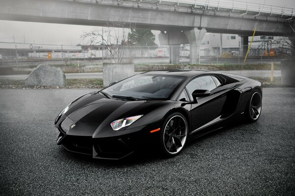 Lambo noir jeté sur un parking abandonné 