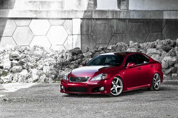 Red Lexus on the background of a pile of stones