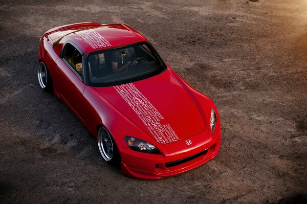 Voiture de sport rouge avec inscriptions sur le toit et le capot