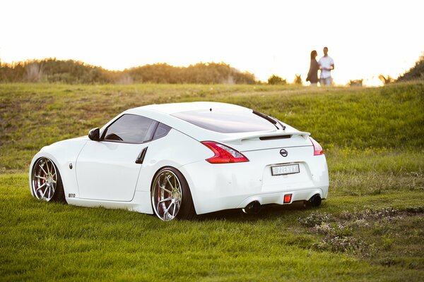 There is a car and a couple in love in the clearing