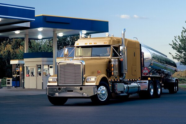 Un gros camion conduit à la station-service