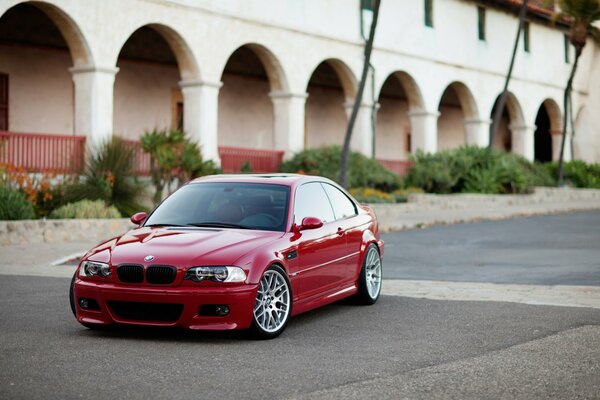 BMW rojo en el sitio cerca del edificio