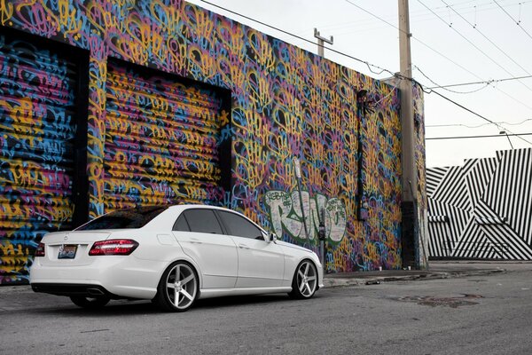 Blanc mercedes classe e sur fond de graffiti